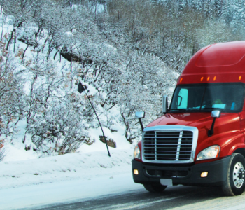 Truck on snowy road way with NDHP logo. Trucking Tip