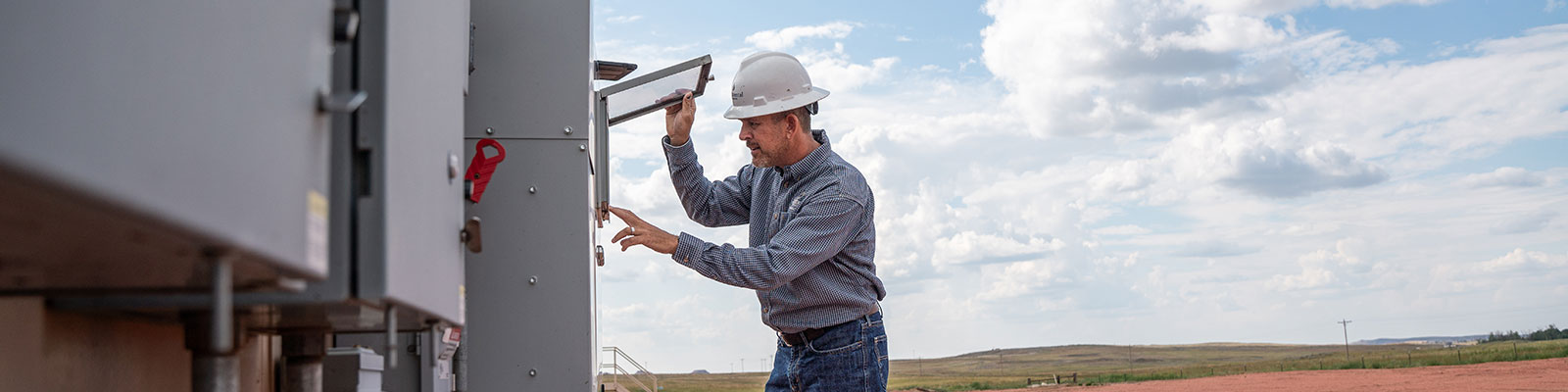 Oil field worker checks instrumentation equipment. 