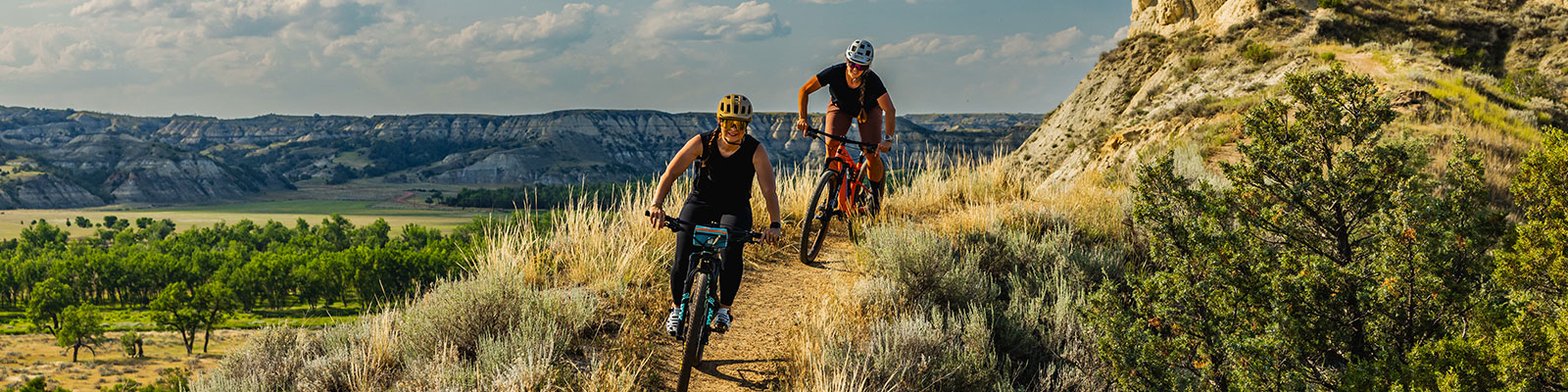 Mountain bike riders adventuring through the rugged North Dakota badlands on the Maah Daah Hey Trail.