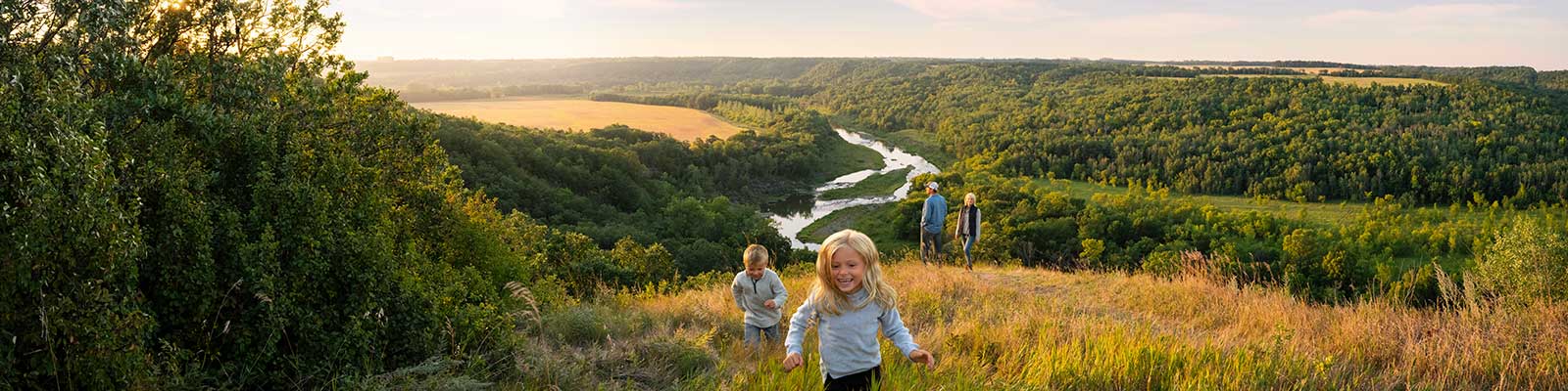 A family runs around in the wide open space overlooking Pembina Gorge.