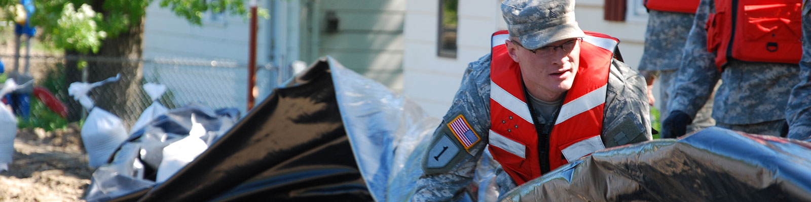 National Guard helping sandbag a flooding area.