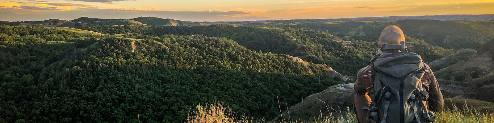 Man sits overlooking the beautiful rugged badlands in western North Dakota.
